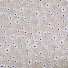 Pattern of small white flowers with black centers on a beige background for Bruna bows by Ruby and Bear