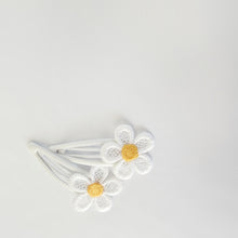 Two white 5cm glossy snap hair clips decorated with white lace daisy flowers that have yellow centers, arranged on a plain white background.